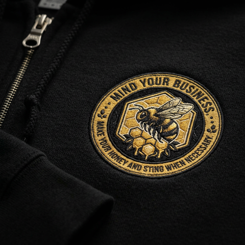 Close-up of Mind Your Business bee badge on hoodie